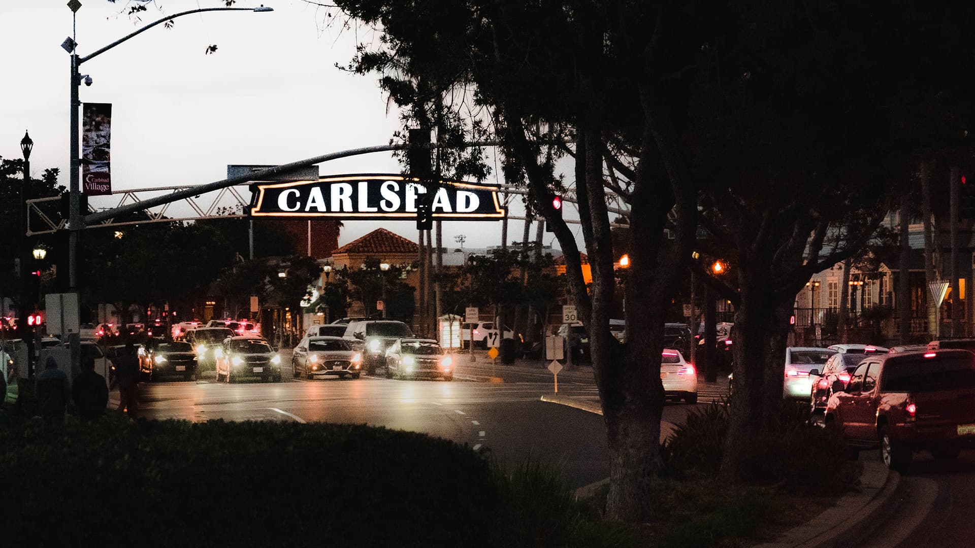 The illuminated Carlsbad Village sign at dusk